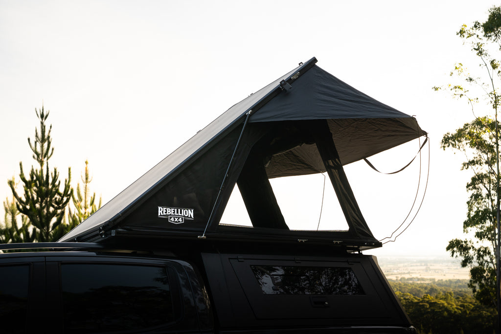 Roof top tent on a vehicle with trees in the background