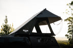 Roof top tent on a vehicle with trees in the background