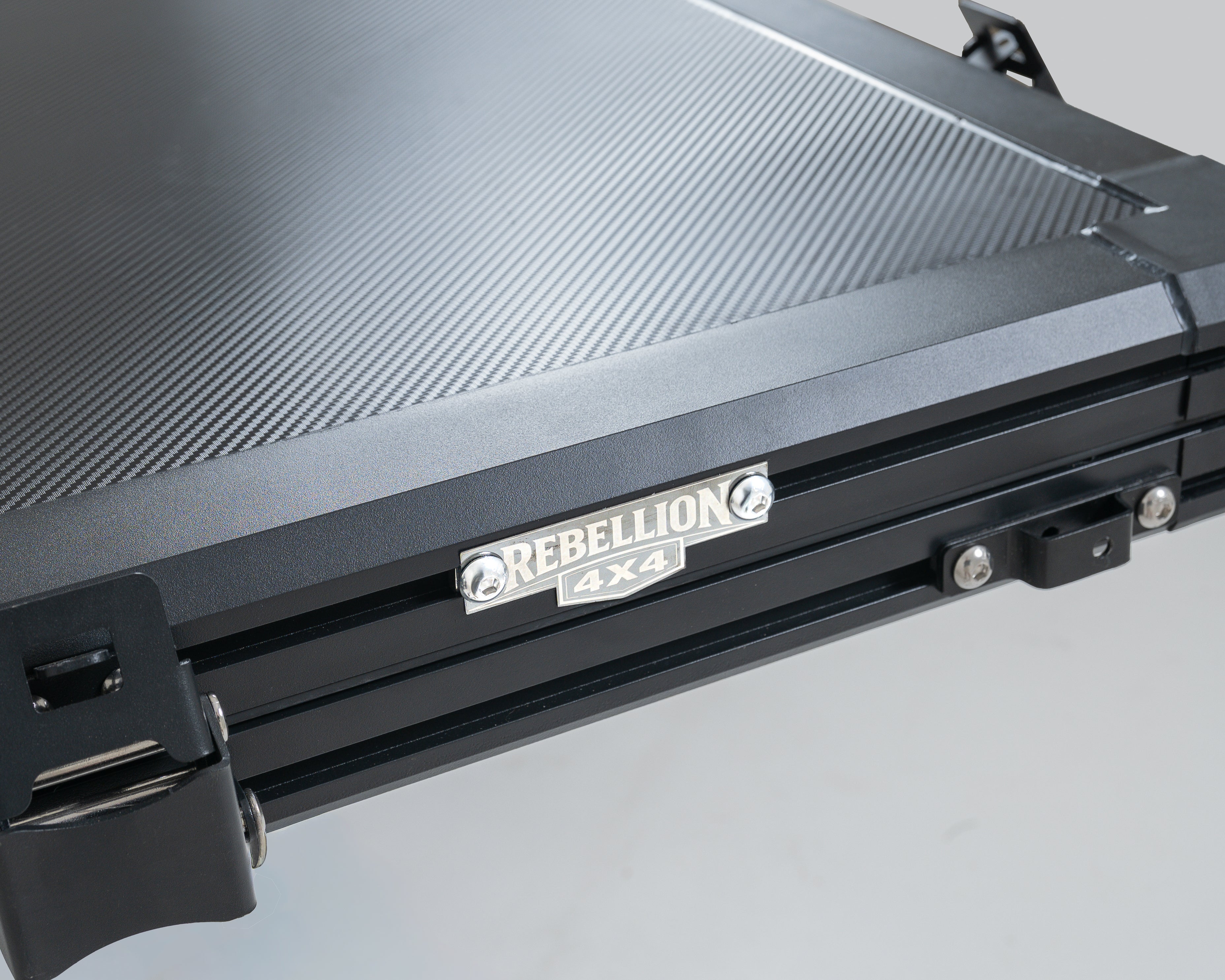Black roof top tent with 'Rebellion 4x4' branding on a gray background